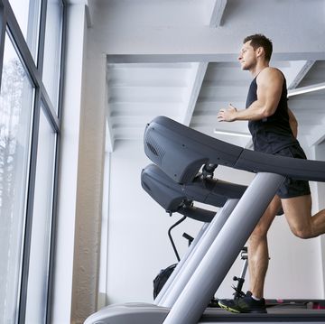 man Face running on treadmill at gym