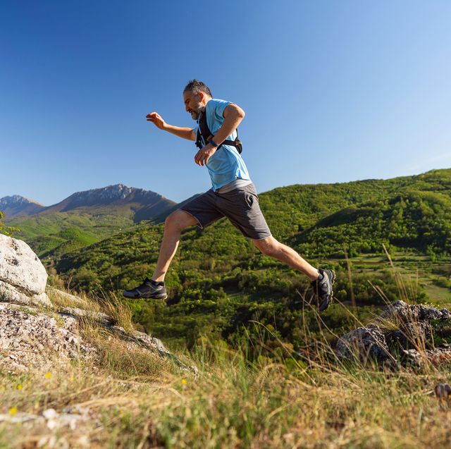 man running over the rocky mountain trail