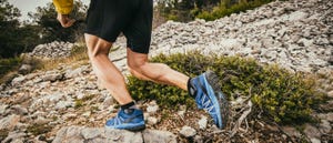 man running up a rocky hill