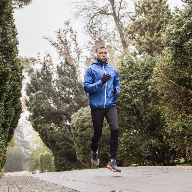 man running with music in foggy outdoor setting