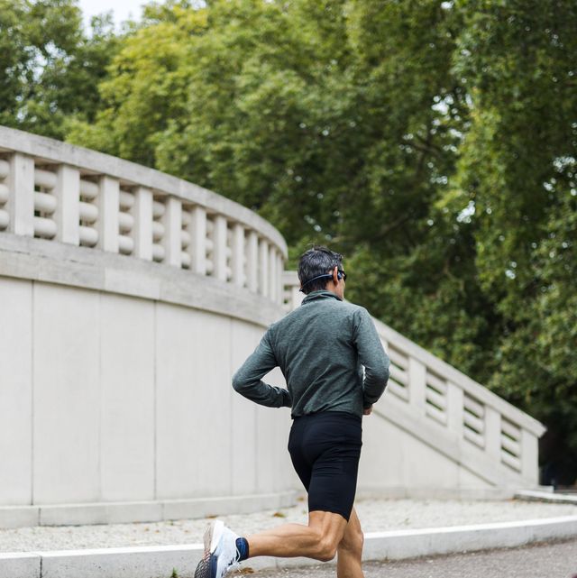 a man runs on a sidewalk in front of a building