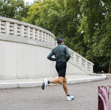 a man runs on a sidewalk in front of a building