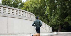 a man runs on a sidewalk in front of a building