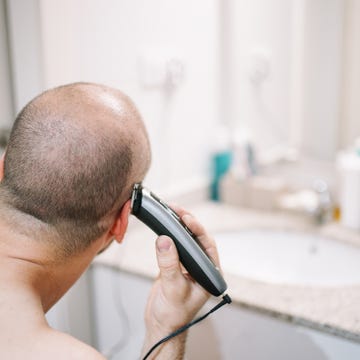 Man Shaving His Head With Electric Razor In Bathroom, Lleida, Spain man shaving his head with electric razor in bathroom, lleida, spain