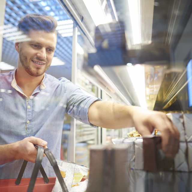 Man shopping for groceries in supermarket freezer