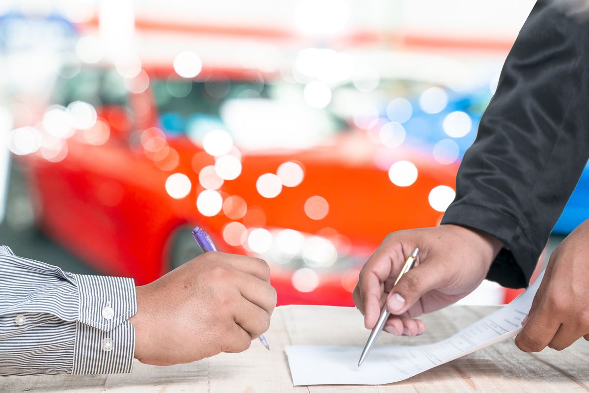 man signing car insurance document or lease paper