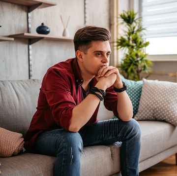 man sitting alone at home looking sad and distraught