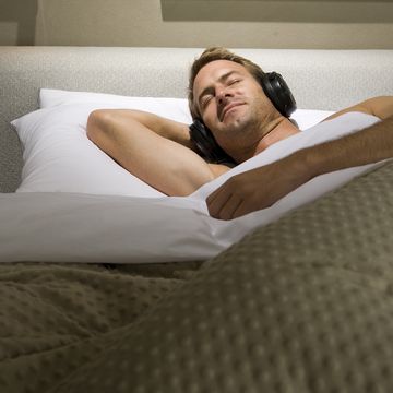 man sleeping in bed with headphones