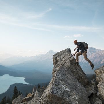 a man standing on a rocky point overlooking peyto lake
