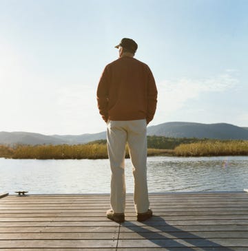 man standing on pier near lake