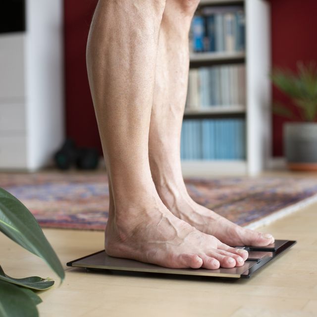 man standing on weight scale, low section