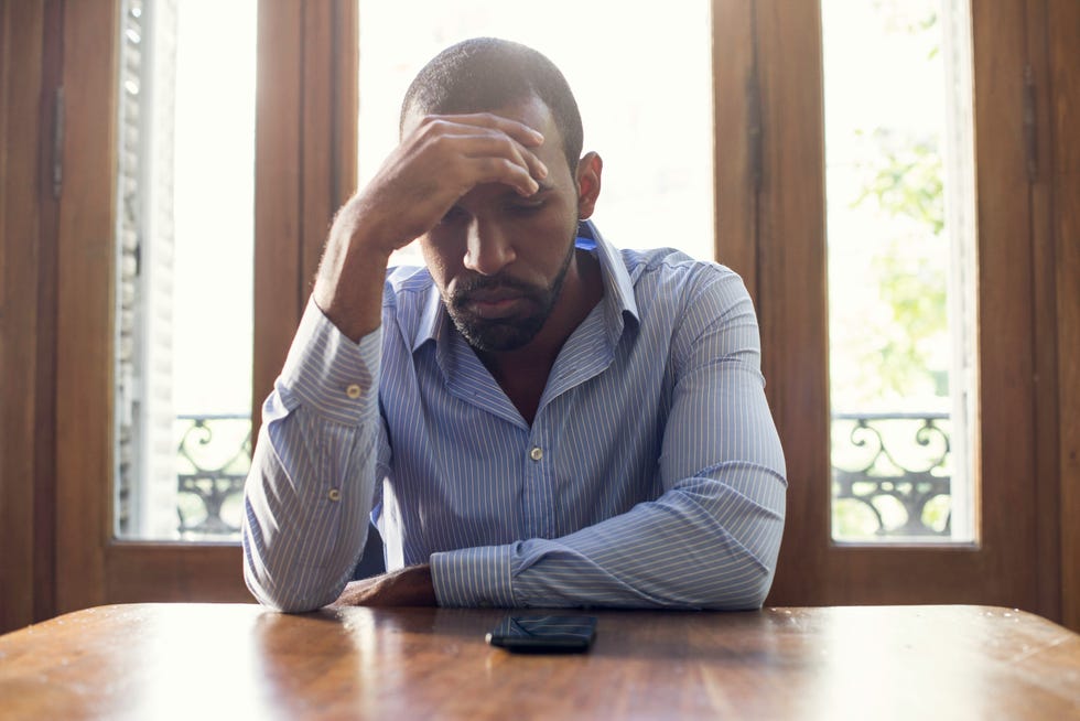 Man staring at cell phone with look of disappointment