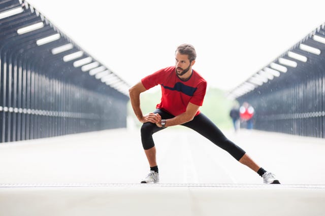 man stetching on a bridge