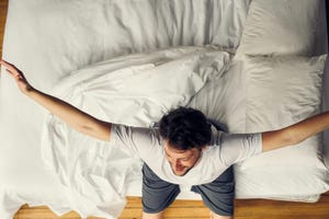 man stretching in bed