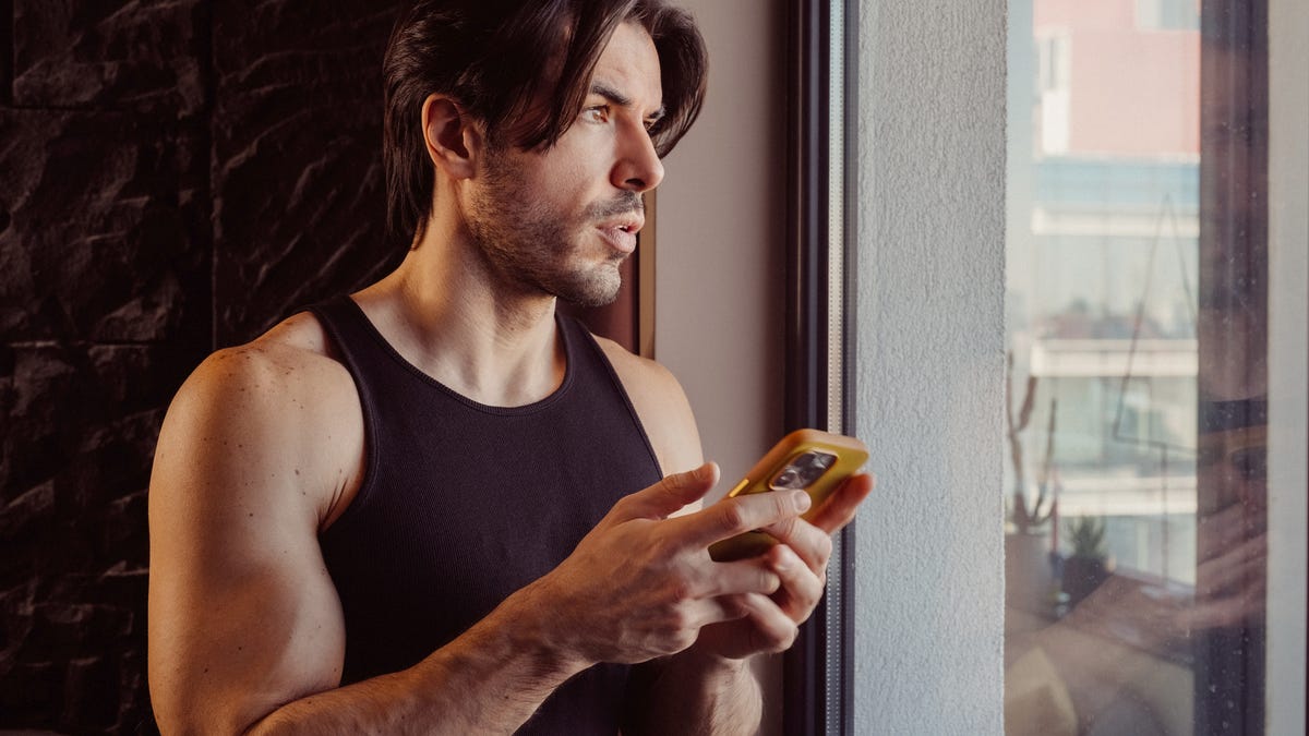 man texting near the window