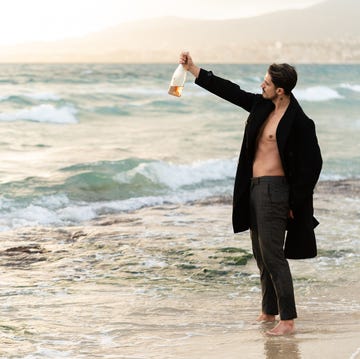 hombre tomando champán en la playa