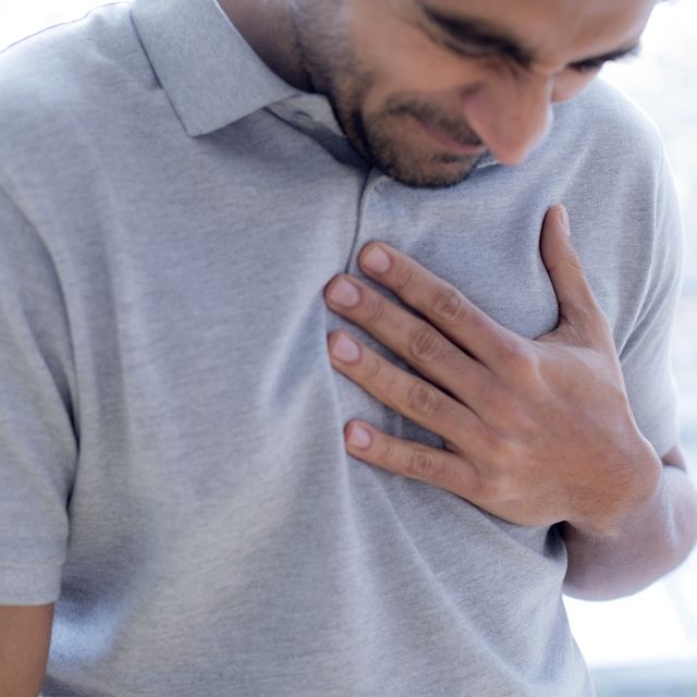man touching his chest in pain