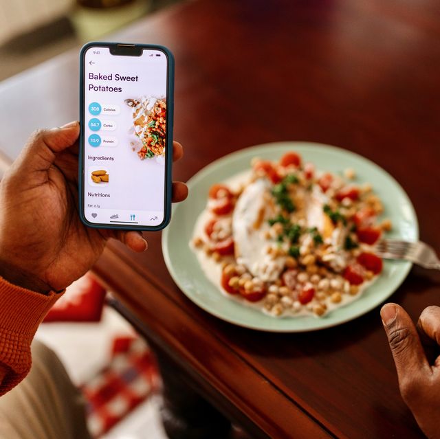 man tracking calorie intake with a mobile app while enjoying a healthy meal