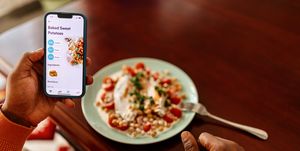 man tracking calorie intake with a mobile app while enjoying a healthy meal