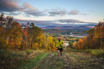 man trail running in mountains during foliage season