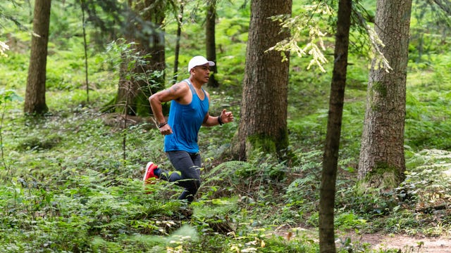 man trail running in the forest