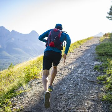 man trail runs along mountain ridge at sunrise