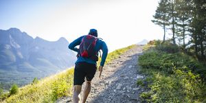 man trail runs along mountain ridge at sunrise