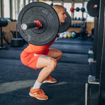 man training on with weights in gym