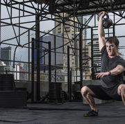 man training with kettle bell at rooftop gym in bangkok