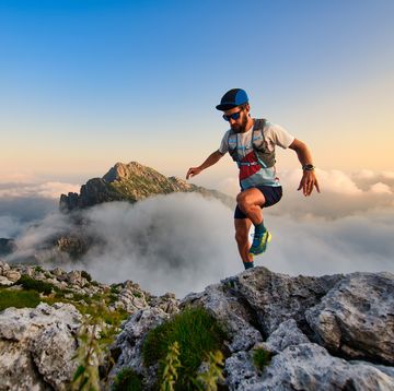 man ultramarathon runner in the mountains he trains at sunset
