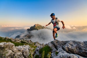 man ultramarathon runner in the mountains he trains at sunset