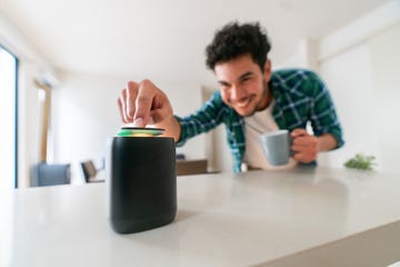 hombre tocando altavoz inteligente