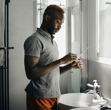 man using corona virus test swab in his bathroom
