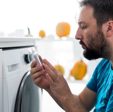 man using digital device washing machine touch screen for smart home functions