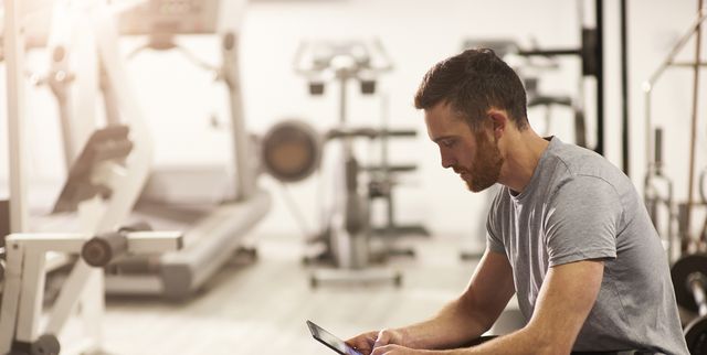Man using digital tablet in gym after exercising.