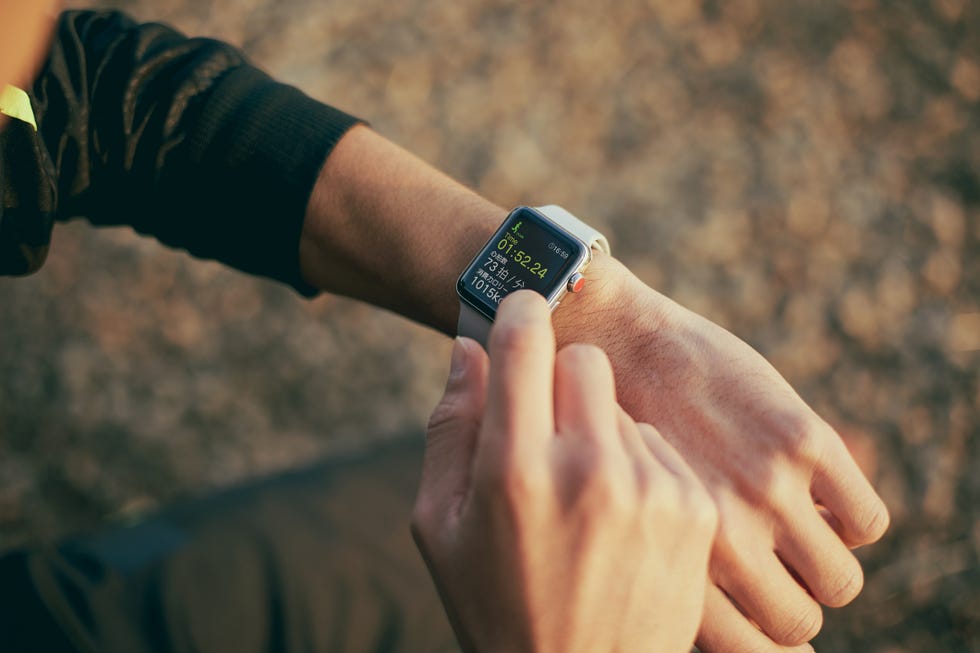 man using his smart watch outdoors