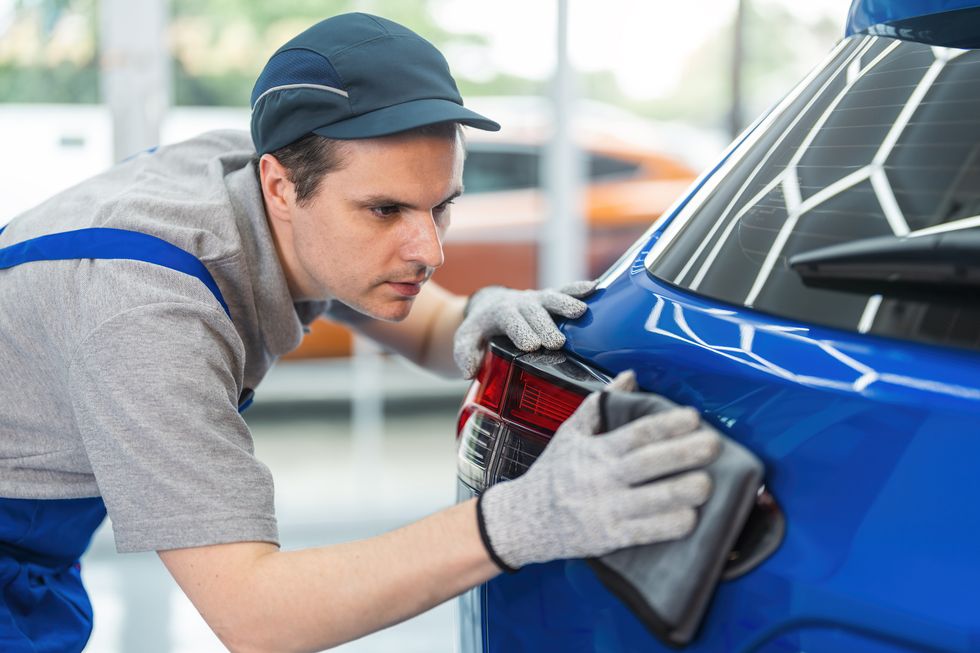 man wiping car exterior with a microfiber cloth