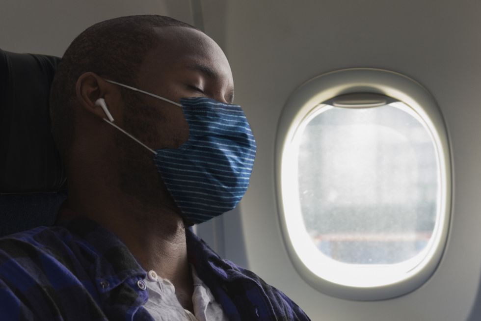 man wearing mask inside airplane