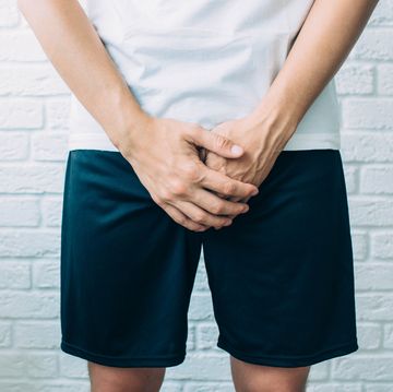 man wearing shorts holding genitals men's health, venereologist, sexual disease
