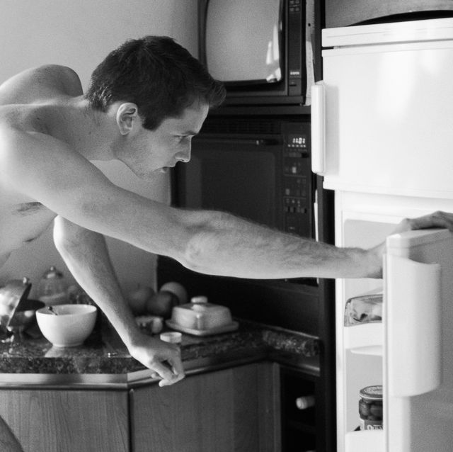 man wearing underwear, bending to look in refrigerator, side view, black and white