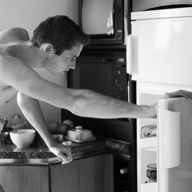 man wearing underwear, bending to look in refrigerator, side view, black and white