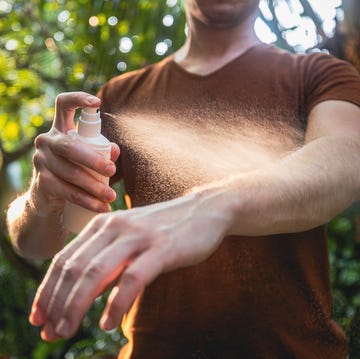 man while applying insect repellent