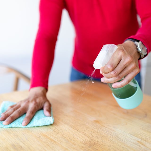 man wiping table surface with disinfectant