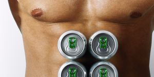 Man with beer cans on chest, mid section
