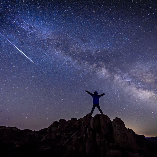 man with bright shooting star under milky way galaxy stargazing calendar