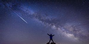 man with bright shooting star under milky way galaxy stargazing calendar