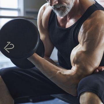 man with dumbbell strengthening biceps in gym