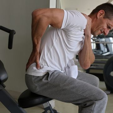 Man with low back pain in gym. Sports exercising injury