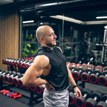 man with low back pain in gym sports exercising injury