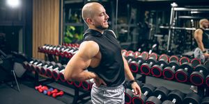 man with low back pain in gym sports exercising injury